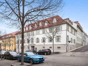 a blue car parked in front of a white building at LudwigsCozyEscape - Historisches Altstadt-Apartment mit Sichtbalken am Residenzschloss, 6 Gäste, SmartTV in jedem Zimmer, Highspeed WLAN, Workspace, 24h Self Check-in, Parkhaus 2 Min Gehweite in Ludwigsburg