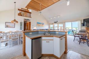 a kitchen with a counter and a dining room at Ocean Wynns - Nags Head MP 13, 20 Yards to the Beach, Ocean Views, Close to Attractions in Nags Head
