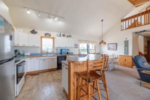 a kitchen with white cabinets and a island with a bar at Ocean Wynns - Nags Head MP 13, 20 Yards to the Beach, Ocean Views, Close to Attractions in Nags Head +64 photos