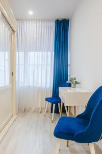 a room with two blue chairs and a table at Damone Residence in Gura Humorului