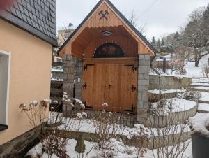a large wooden door of a building in the snow at Ferienwohnung Dick Schwarzenberg in Schwarzenberg +1 photo