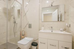 a bathroom with a toilet and a sink and a shower at Damone Residence in Gura Humorului