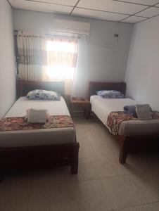 a room with two beds and a window at Hotel Gallineral in San Martín