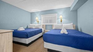 two beds in a room with blue walls at Beachfront WW Crest Condo Sleeps 6 in Wildwood Crest