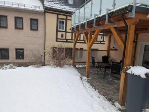 a patio with a deck in the snow at Ferienwohnung Dick Schwarzenberg in Schwarzenberg