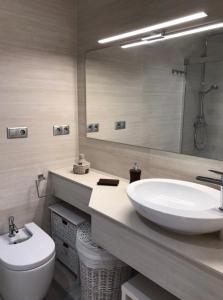 a bathroom with a sink and a toilet and a mirror at PuertoHouse in El Puerto de Santa María +60 photos