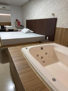 a large bath tub in a bedroom with a bed at Motel Canadá moto gp in Senador Canedo +17 photos