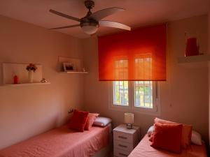 a bedroom with two beds and a ceiling fan at PuertoHouse in El Puerto de Santa María
