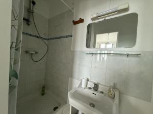 a white bathroom with a sink and a mirror at L'appartement Dunois in Châteaudun