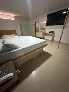 a bedroom with a large bed and a television at Motel Canadá moto gp in Senador Canedo