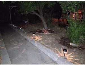 two lights on the sidewalk near a tree at night at Sunny Home in Anaxos