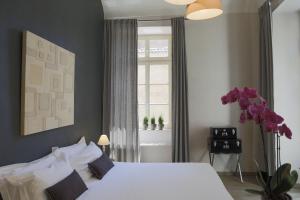 um quarto com uma cama branca e uma janela em Residenza Dell' Opera em Turim