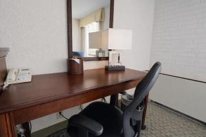 a desk with a mirror and a chair at Hotel Lotus Kansas City Stadium in Kansas City