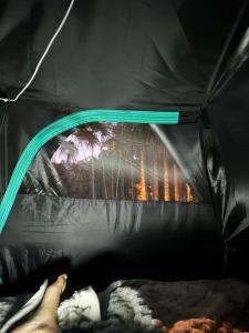 a person laying in a tent with their feet in it at Camping Místico - Vale do Ribeira in Juquiá