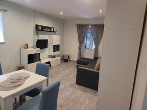 a living room with a couch and a table and chairs at Apartment Central in Šibenik