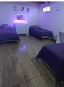 a bedroom with two beds and a dresser with a light at Nafaro in Villa Gesell