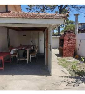 a patio with a table and chairs under a pavilion at Nafaro in Villa Gesell