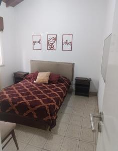 a bedroom with a bed and three pictures on the wall at Nafaro in Villa Gesell