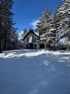 a white house in the snow with trees at Golden peak Blidinje in Blidinje