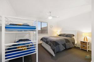 ein Schlafzimmer mit einem Bett und einem weißen Etagenbett in der Unterkunft Seagulls in Lancelin