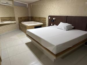 a bedroom with a bed and a bath tub at Motel Canadá moto gp in Senador Canedo