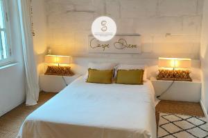 a bedroom with a white bed with two lamps at Coté Nature Arles Centre in Arles
