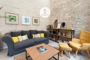 a living room with a blue couch and a table at Coté Nature Arles Centre in Arles