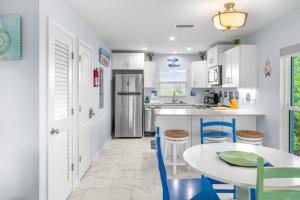 a kitchen with white cabinets and a table and chairs at Seashells Unit 44 in Sanibel