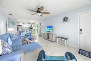 a living room with a blue couch and a tv at Seashells Unit 44 in Sanibel