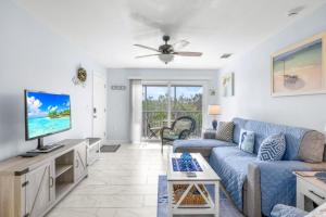 a living room with a blue couch and a tv at Seashells Unit 44 in Sanibel