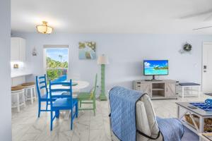 a living room with a table and chairs and a tv at Seashells Unit 44 in Sanibel +22 photos