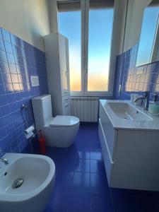 a blue bathroom with a toilet and a sink at Interno24 Apartment in La Spezia +19 photos