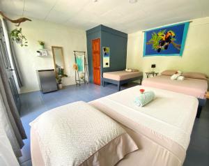 a room with two beds and a television in it at Rooms & Pool Macaws in Uvita