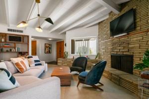a living room with a couch and a fireplace at Joshua Tree Mid Mod - Pool - Spa - Sauna - Fire pit in Yucca Valley
