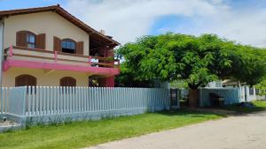 a house with a fence and a tree at Residencial Lumar in Itapoa