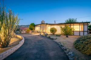 a house with a driveway in front of it at Joshua Tree Mid Mod - Pool - Spa - Sauna - Fire pit in Yucca Valley