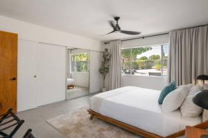 a bedroom with a white bed and a large window at Joshua Tree Mid Mod - Pool - Spa - Sauna - Fire pit in Yucca Valley +59 photos