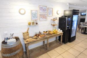 a kitchen with a wooden table and a refrigerator at Aux Genêts D'Or in Trévé
