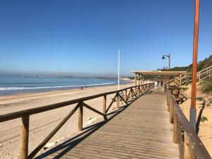 a wooden boardwalk leading down to the beach at PuertoHouse in El Puerto de Santa María