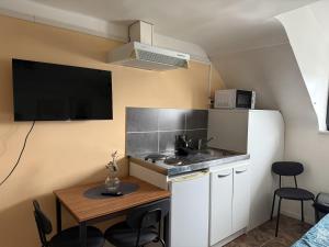 a small kitchen with a table and a sink at Le Studio Dunois in Châteaudun +17 photos
