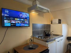a kitchen with a tv hanging on the wall at Le Studio Dunois in Châteaudun