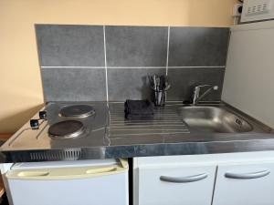 a kitchen with a stove and a sink at Le Studio Dunois in Châteaudun