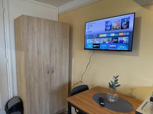 a room with a table and a television on the wall at Le Studio Dunois in Châteaudun