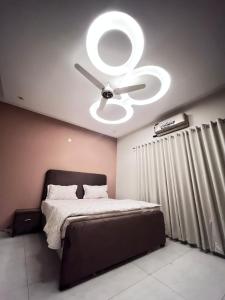 a bedroom with a bed with a ceiling fan at Livora stays Cozy Luxury 1BHK in Multan