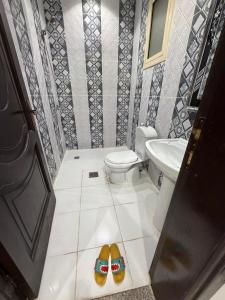a bathroom with a toilet and a pair of shoes at النبلاء الفضي in Medina