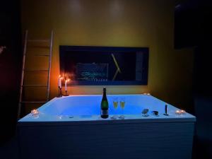 a bath tub with a bottle of wine in it at Cc love in Carbonne