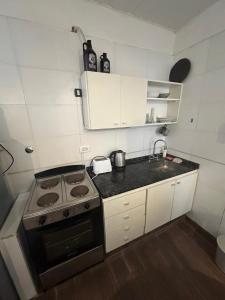 a small kitchen with a stove and a sink at Exclusivo Apartamento Centro Laguna in Chascomús +2 photos