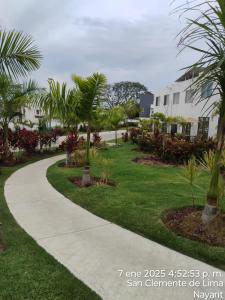 a walkway through a park with palm trees at CASA CON ALBERCA Rodeada de NATURALEZA in Naranjo