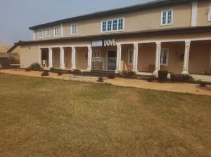 a large building with a large yard in front of it at Crown Dove in Benin City
