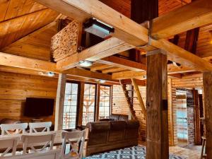 a living room with wooden walls and a ceiling with beams at Lozanski ambar in Boljevac